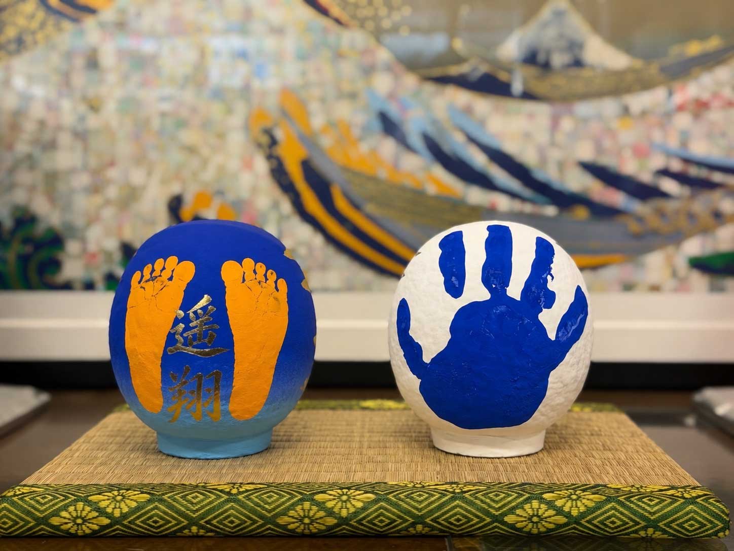 手形と足形を押した高崎だるまの作品。名入れをした一体と、手形をそのまま活かした一体